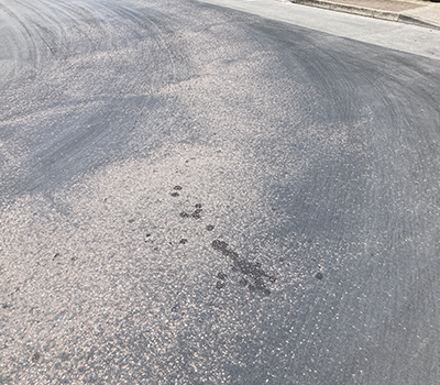 Image of worn asphalt gone smooth on a car park